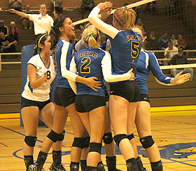 MCC players celebrate on the court after sweeping the first six points in game one against GRCC.