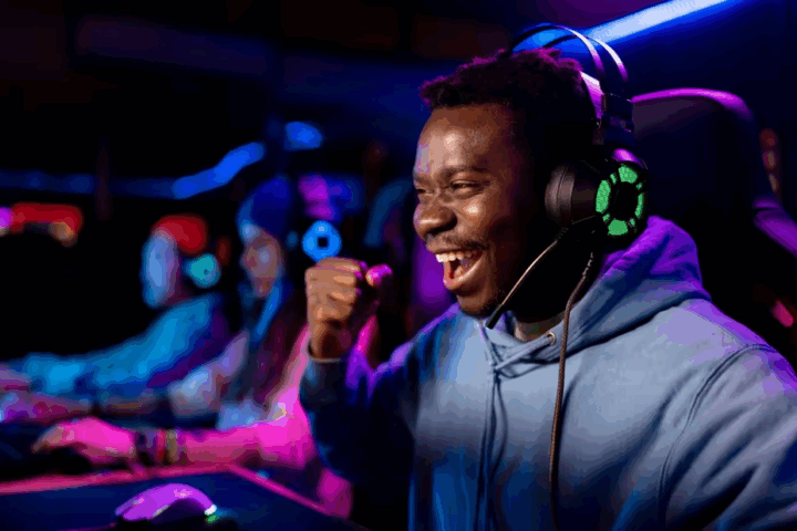 A person playing ESPORTS smiles and pumps his fist in victory.