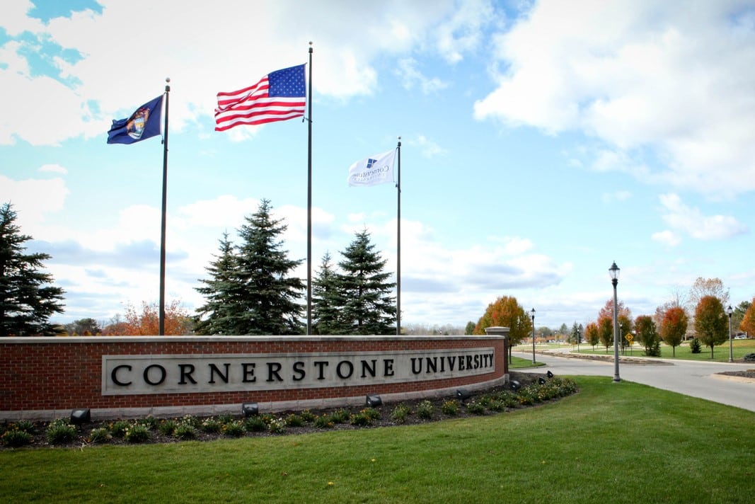Cornerstone University sign with flags waving in the sky